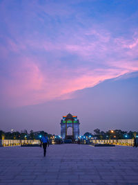 Illuminated building against sky at sunset