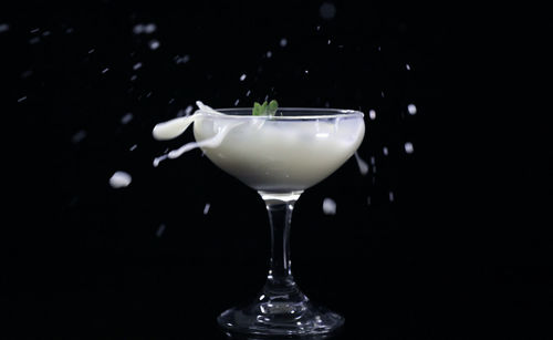 Close-up of wine glass against black background