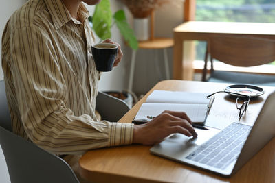 Midsection of woman using laptop