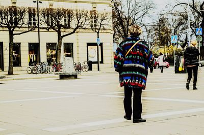 Rear view of people walking in city