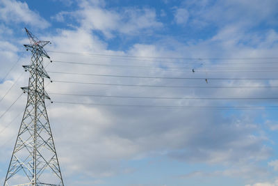 Low angle view of electricity pylon against sky