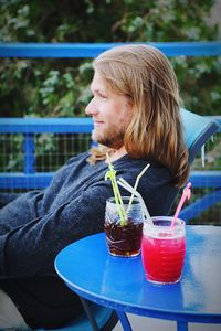 Side view of smiling man with drinks on table