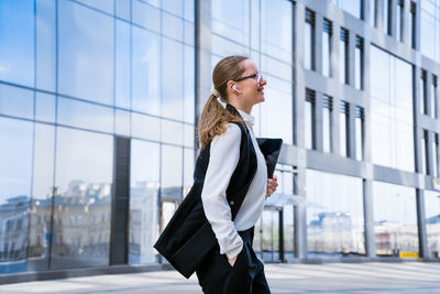 Portrait of successful business woman in stylish suit using laptop posing next