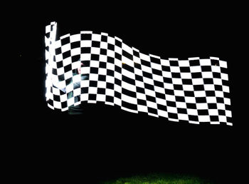 Close-up of illuminated lighting equipment on black background