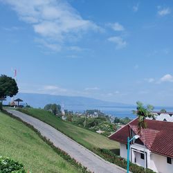 Houses by road against sky in city