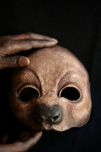 Close-up portrait of human hand against black background