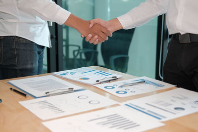 Midsection of man and woman standing on table