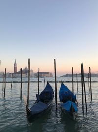 Boats moored in sea against clear sky