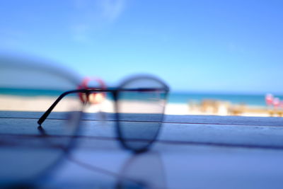 Close-up of sunglasses on beach