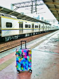 Multi colored train on railroad station platform