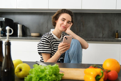 Portrait of smiling young woman sitting at home