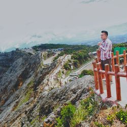 Man standing on rock looking at mountain