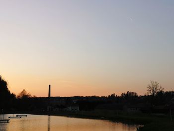 Scenic view of lake against clear sky during sunset