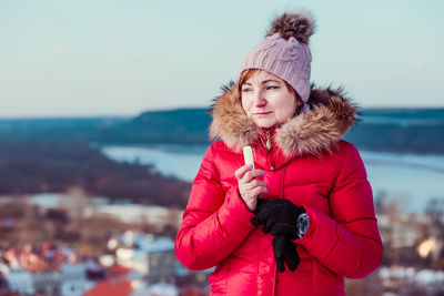 Smiling woman wearing winter coat and knit hat