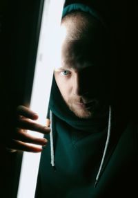 Close-up portrait of young man holding window