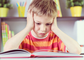 Tensed boy studying at home