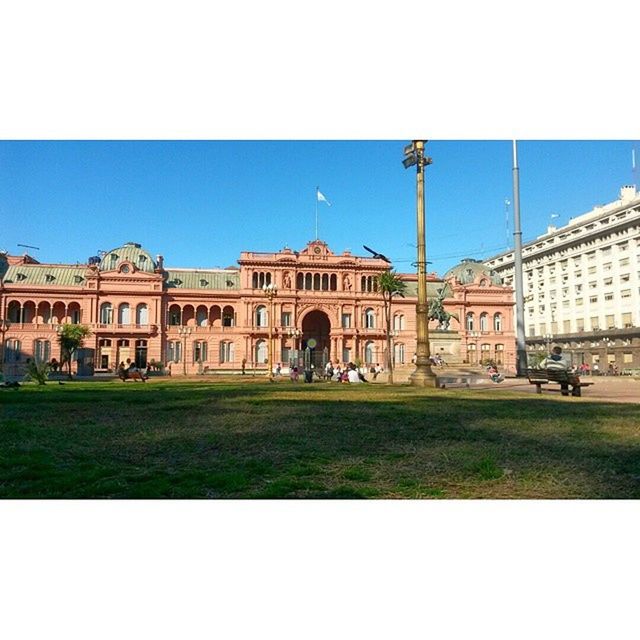 architecture, building exterior, built structure, grass, transfer print, clear sky, lawn, large group of people, city, famous place, travel destinations, facade, auto post production filter, incidental people, history, tourism, sky, men, tourist