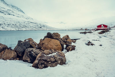 Rocks on snowy riverbank landscape photo