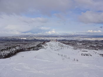 Scenic view of snow covered land against sky