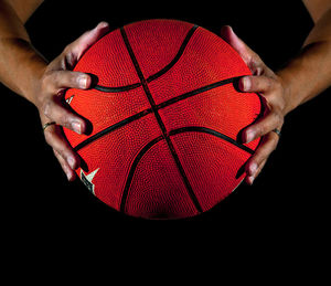Midsection of man holding basketball