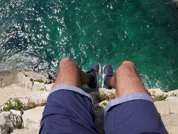 Low section of man legs against sea