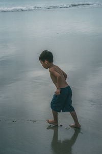 Full length of shirtless boy on beach