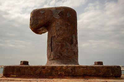 Low angle view of old rusty metal against sky