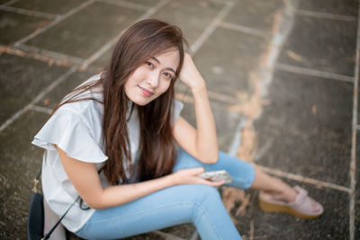 Portrait of a smiling young woman sitting outdoors