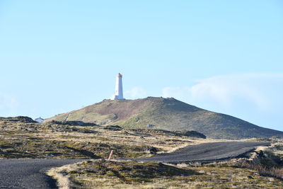 Lighthouse on mountain against sky