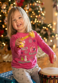 Portrait of girl playing drum at home