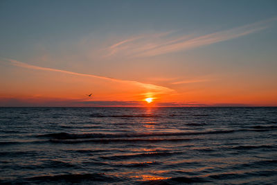 Scenic view of sea against cloudy sky during sunset