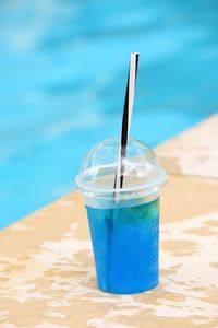 Close-up of drink on table at swimming pool