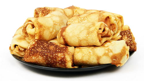 Close-up of pancakes in plate on white background