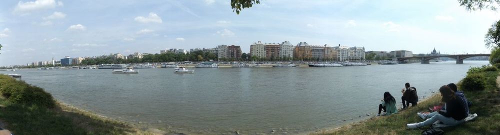 Boats in river with city in background