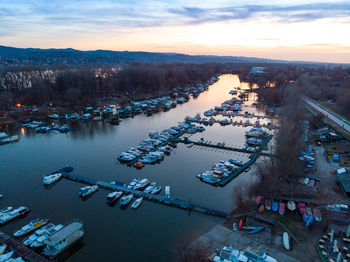 High angle view of boats moored at harbor during sunset