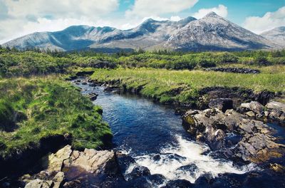  landscape scenery with small river and mountains in the background at connemara, galway, ireland