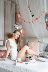 Portrait of woman sitting on bed at home