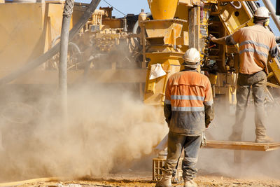 Rear view of people working at construction site