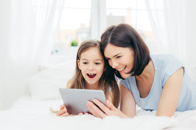 Portrait of mother and woman using mobile phone