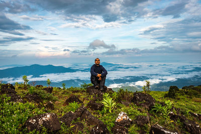 Man standing on rock against sky