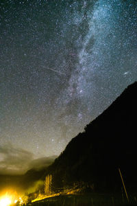 Low angle view of silhouette mountain against sky at night