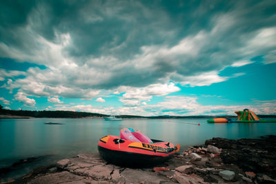 Boat moored on lake against sky