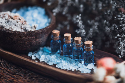 Close-up of rock salt and bottles in tray