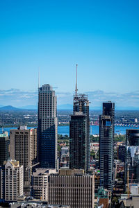 Skyscrapers under construction site in city against clear blue sky