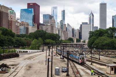 Panoramic view of railroad tracks amidst buildings in city against sky