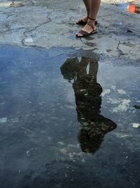 Low section of man standing on puddle