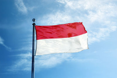 Low angle view of flag against blue sky