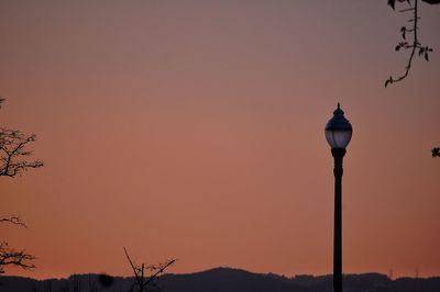 Low angle view of street light against orange sky