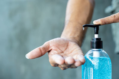 Midsection of man holding bottle in water