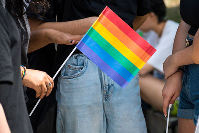 People in the pride parade on the street with gay rainbow flag, supporting gay rights and diversity